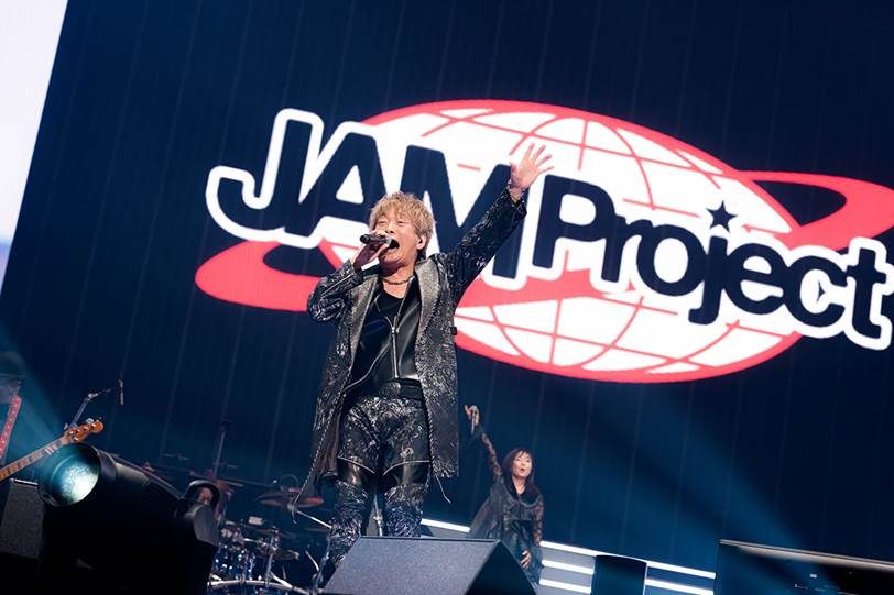 Hironobu Kageyama cantando ao vivo diante do logo do JAM Project