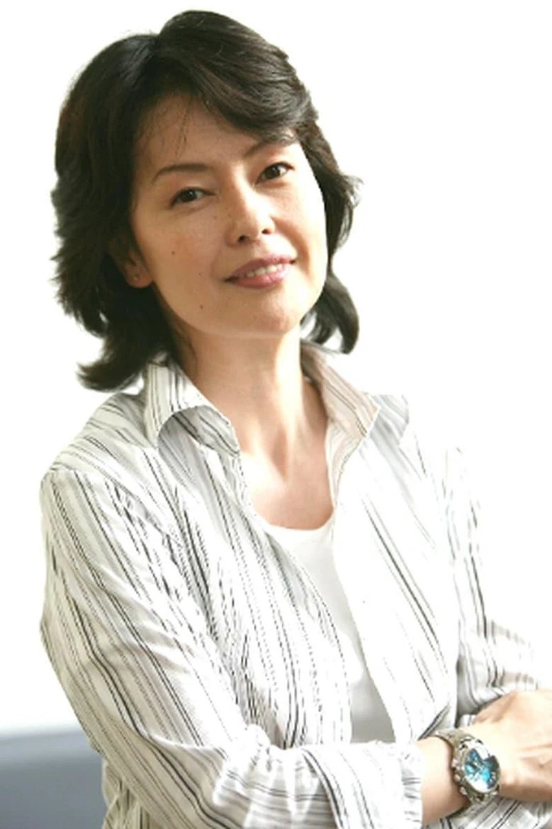 Portrait of a smiling Moyu Taguchi in a white striped shirt with her arms crossed