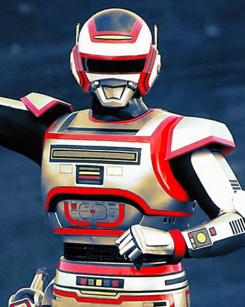 Jaspion de braço estendido, com o traje prateado e vermelho, diante de um fundo azul