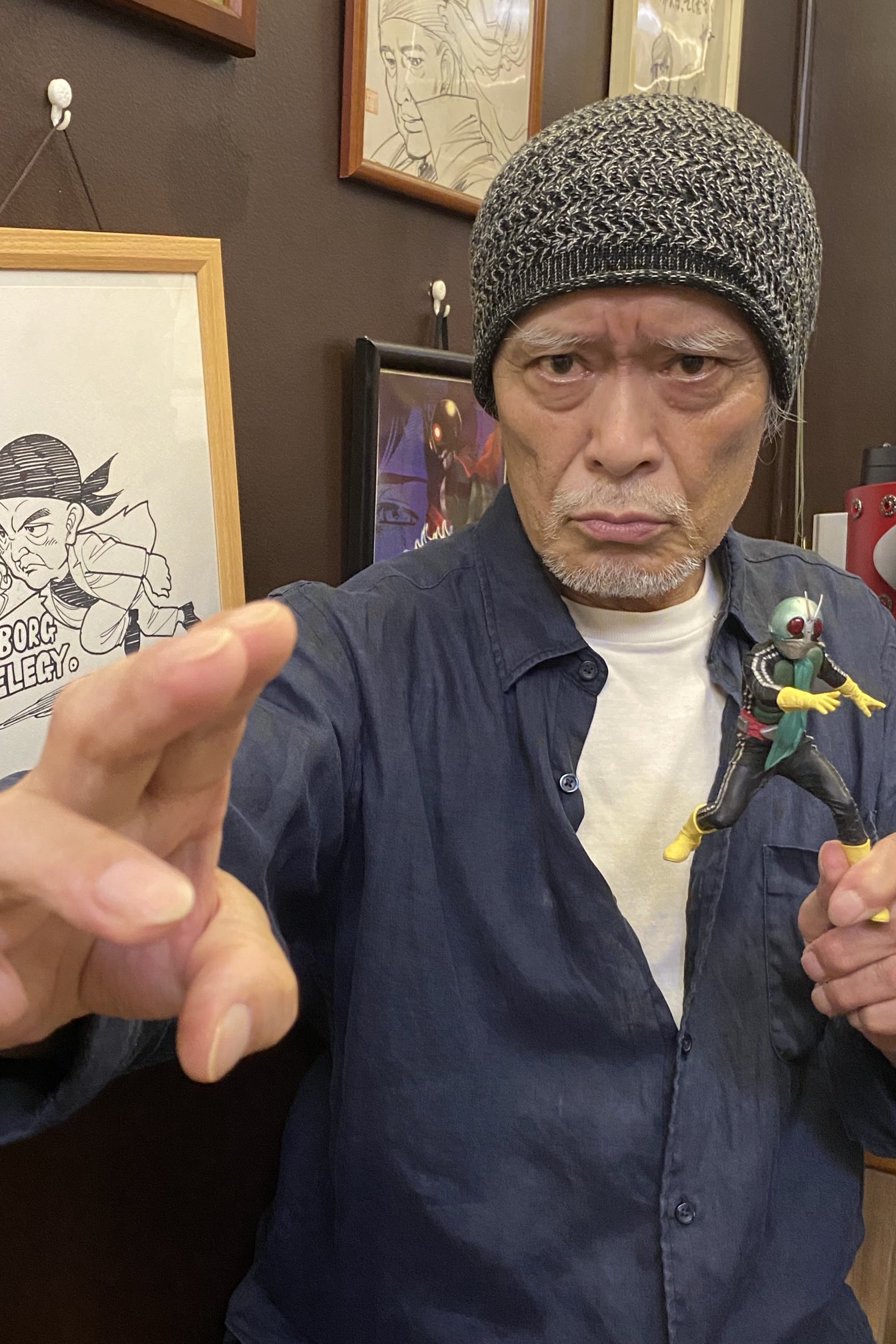 Kazuo Niibori hoje, em seu ateliê, segurando uma figura de Kamen Rider